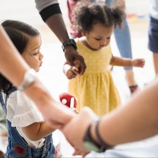 young children holding hands with adults